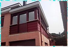 Cerramiento de terraza en PVC oscilo-batiente con persianas trmicas en blanco interior- rojo exterior en Collado Mediano